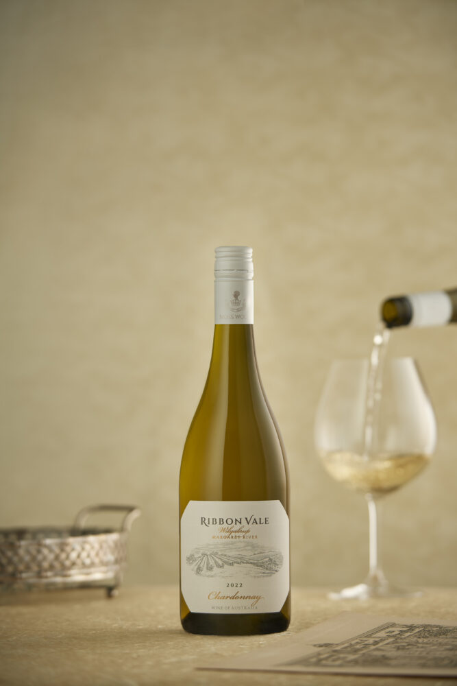 A bottle of Ribbon Vale 2022 Chardonnay with a glass being poured in the background