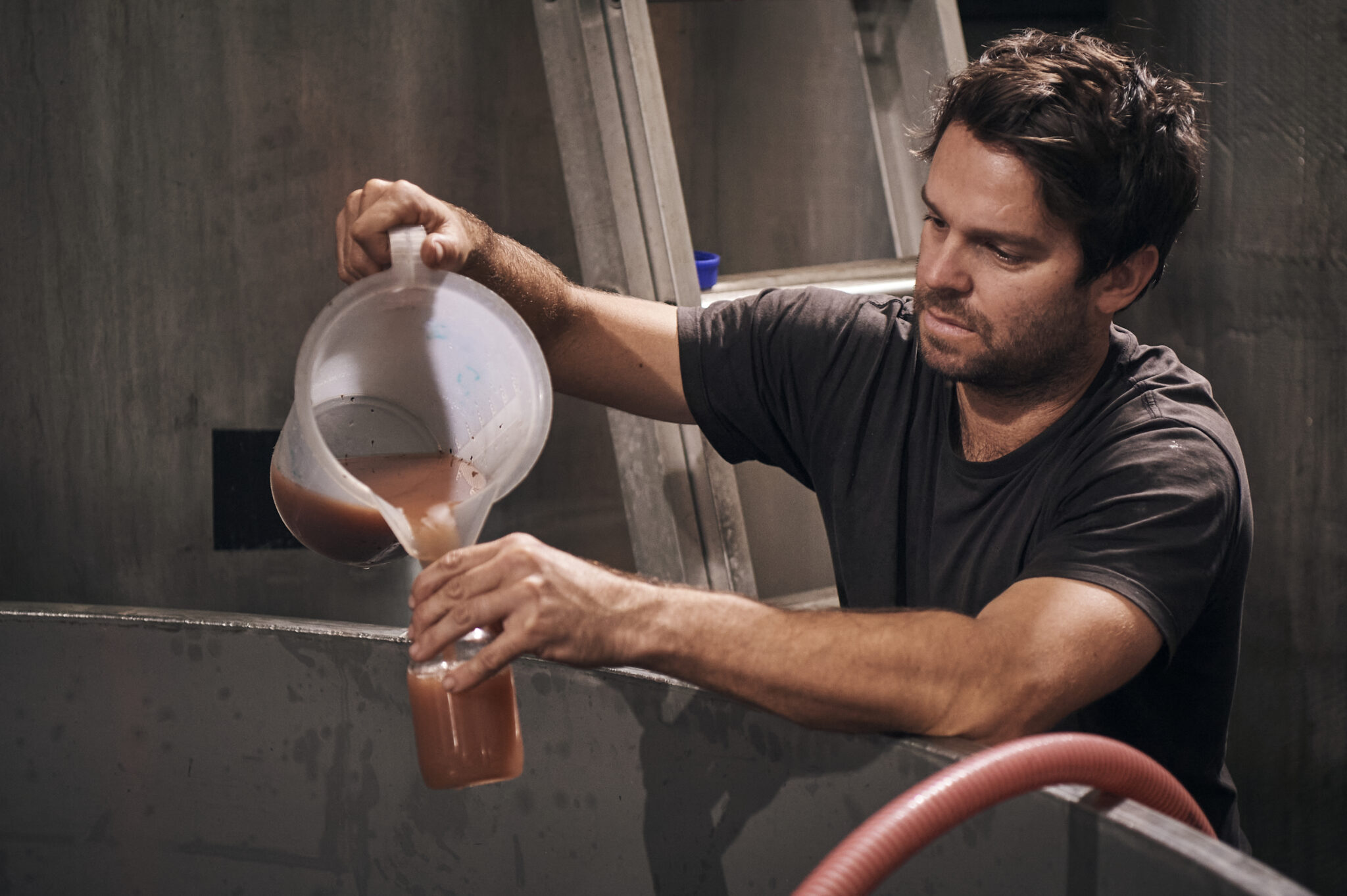 A Moss Wood worker pouring liquid into a glass jar