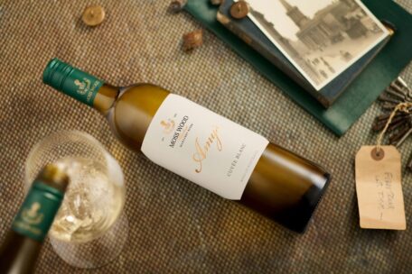 Flat image of Amy’s Cuvée Blanc, with wine pouring into a glass