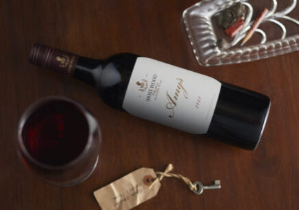 A bottle of Moss Wood 2021 Amy's Vintage laying on a table with a full glass of wine